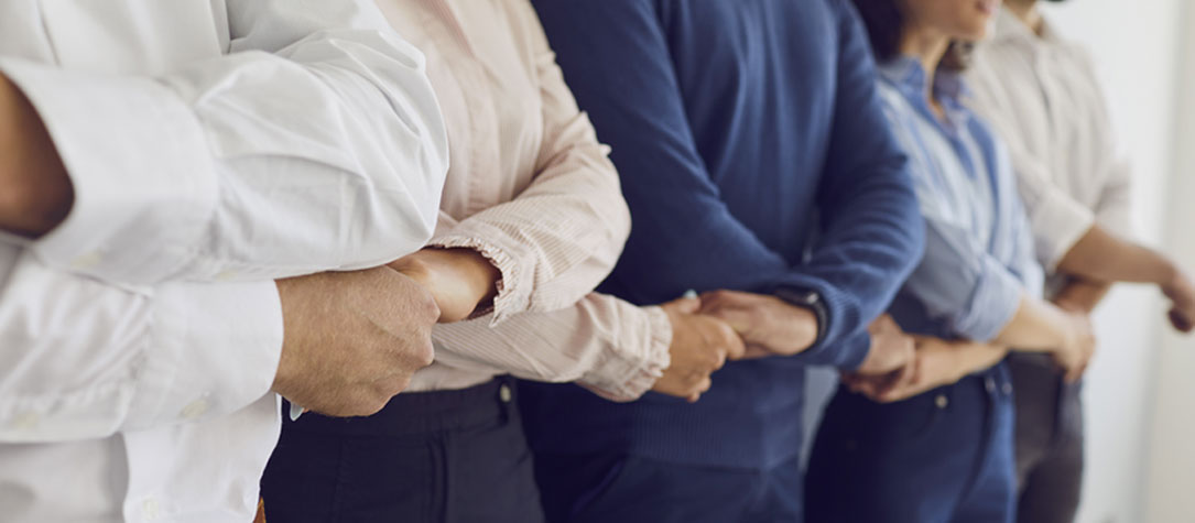 Adults holding hands with crossed arms